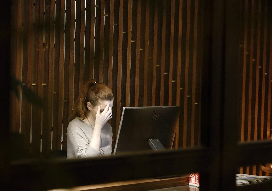 Photo by Vasilis Caravitis a woman sitting in front of a laptop computer